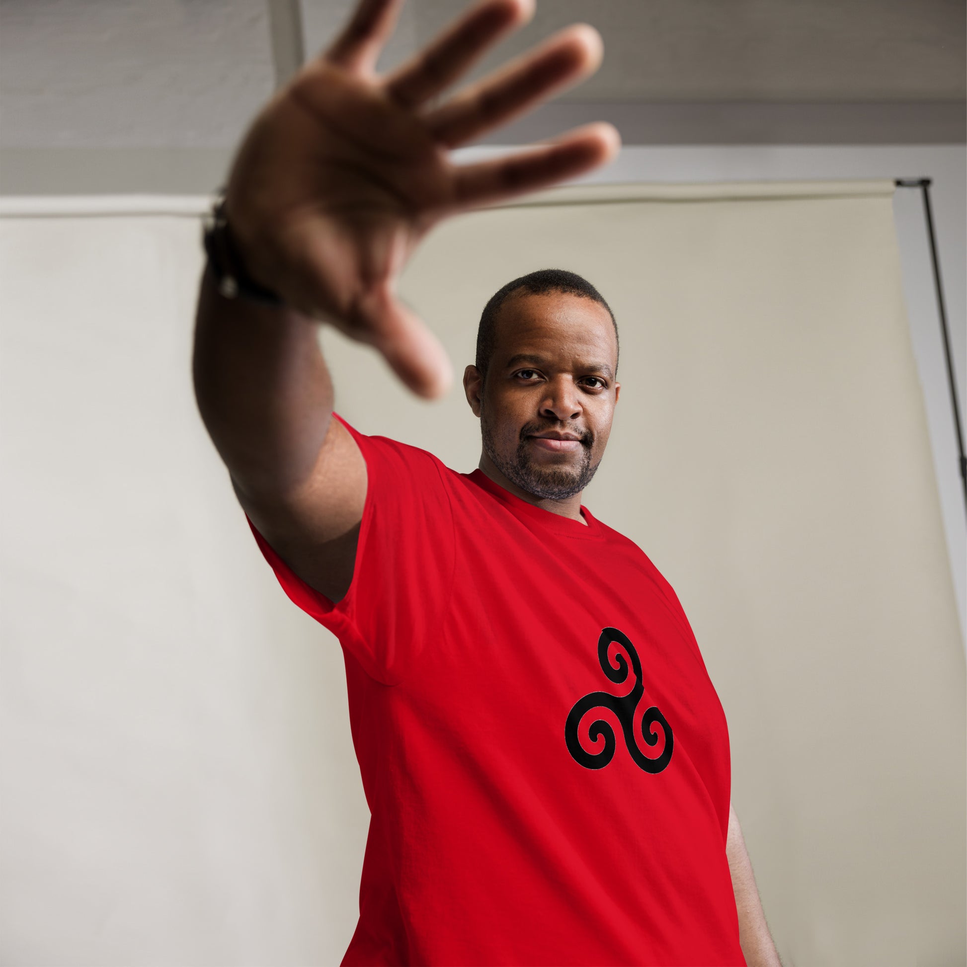 Triskelion T-Shirt design on a red background.